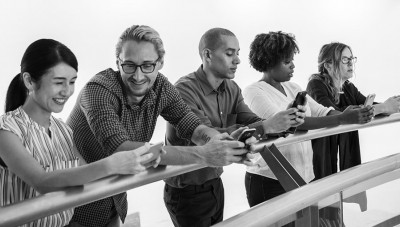 5 people using the Limitless app on their phones whilst leaning on a fence.